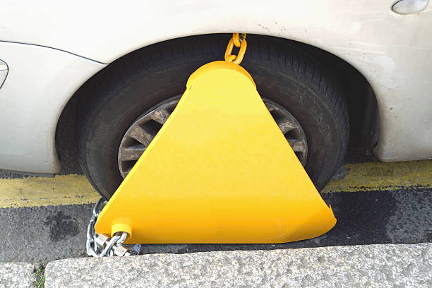 Wheel clamp Yellow clamp on a wheel of illegally parked car car boot stock pictures, royalty-free photos & images