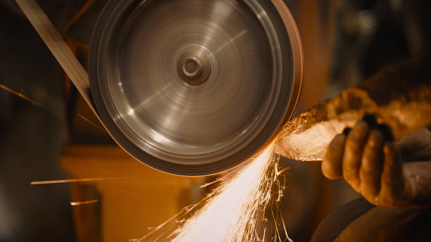istock Craftsman uses a belt sander in machine shop. 515520858
