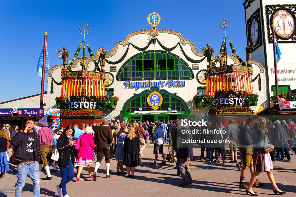 Oktoberfest in Munich Munich, Germany - September 23, 2014: The Oktoberfest in Munich is the biggest beer festival of the world. The visitors are walking at a main street beside many amusement huts and the famous large tents of bavarian breweries. Activity Stock Photo