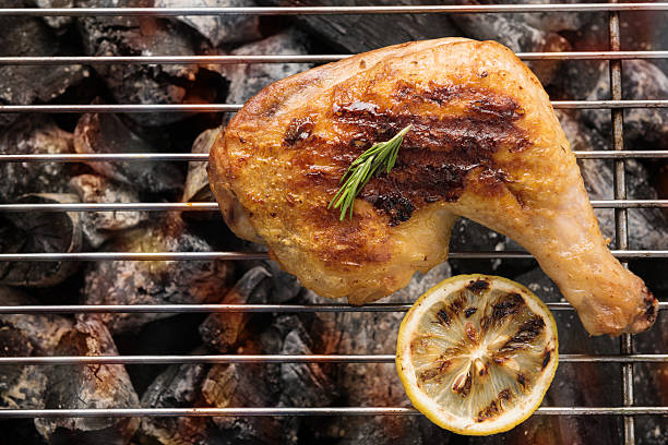 Grilled chicken leg over flames on a barbecue