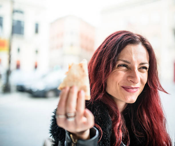 istock woman eating a pizza at restaurant 515529060