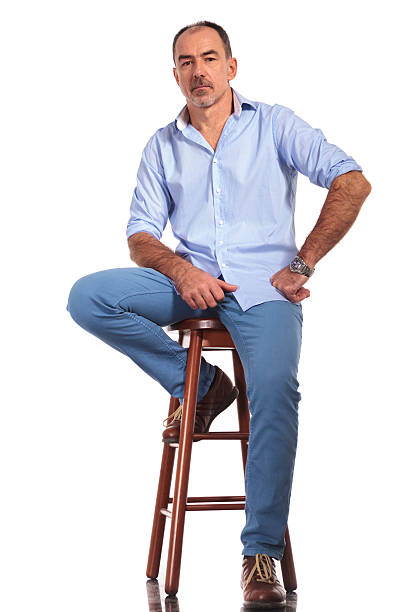 istock confident mature casual man posing seated on chair 515532860