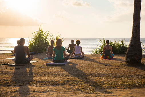 Balangan, Bali, Indonesia - August 9, 2014: Bali is a spiritual place where people from all the world can practise spiritual arts and exercises. In the beach of Balangan every morning and every afternoon before the sunset offer a wonderful experience for yoga practices.