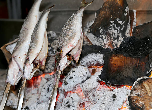 istock Cooking fish grilled over hot coals bonfire 515553751