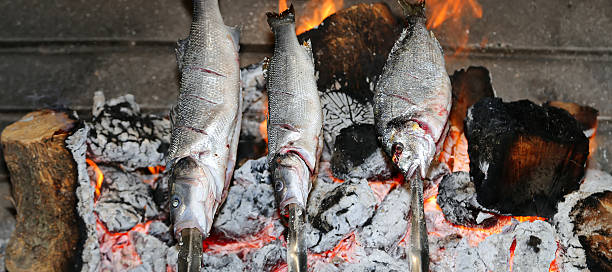 istock Cooking fish grilled over hot coals bonfire 515553755