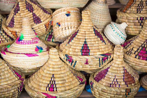 Traditional wicker tajines stacked in a shop in Marrakesh Souq or medina