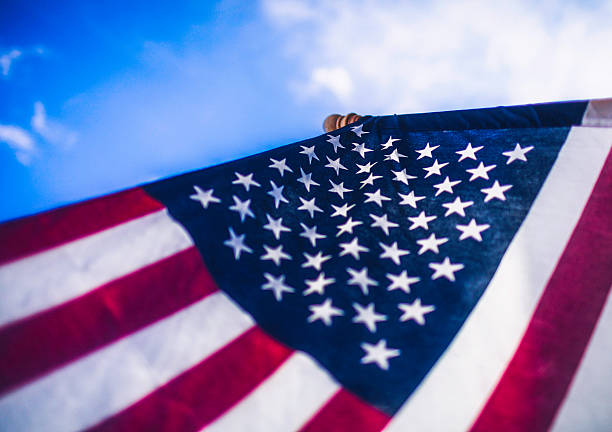 istock American Flag Against Blue Sky 515578707