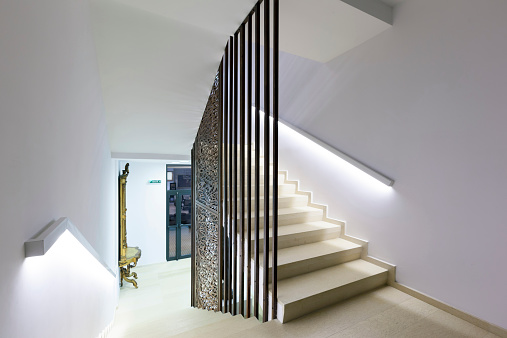 Hall way to private house and staircase to second floor. Illuminated wooden staircase.
