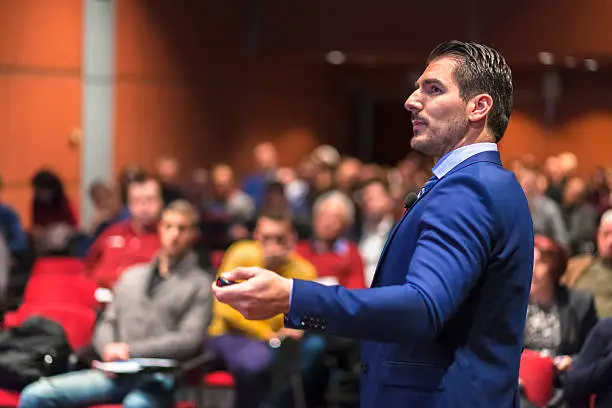 Photo of Public speaker giving talk at Business Event.