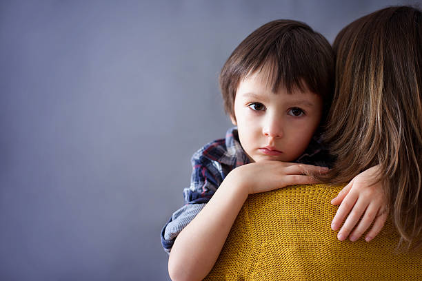 triste poco hijo, niño, abrazando a su madre en su casa - little boys child sadness depression fotografías e imágenes de stock