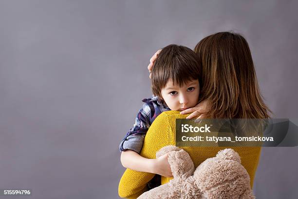 Triste Poco Hijo Niño Abrazando A Su Madre En Su Casa Foto de stock y más banco de imágenes de Niño