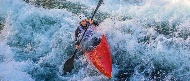 Woman kayaking Woman rowing oar while enjoying kayaking in white water. kayak surfing stock pictures, royalty-free photos & images