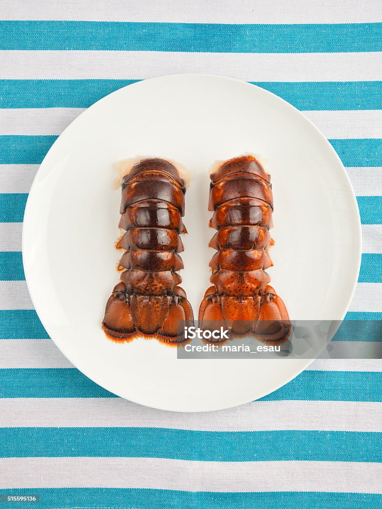 Two lobster tails on plate top view Two lobster tails on plate top view on striped texture Lobster - Animal Stock Photo