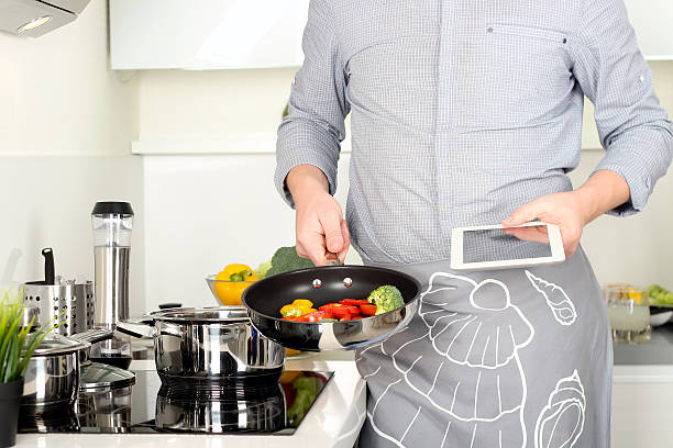 istock cooking, technology and home concept -man pointing finger to computer 515597764