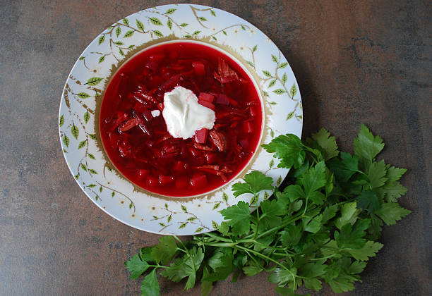 istock Beetroot soup in plate with parsley on brown background. 515599438