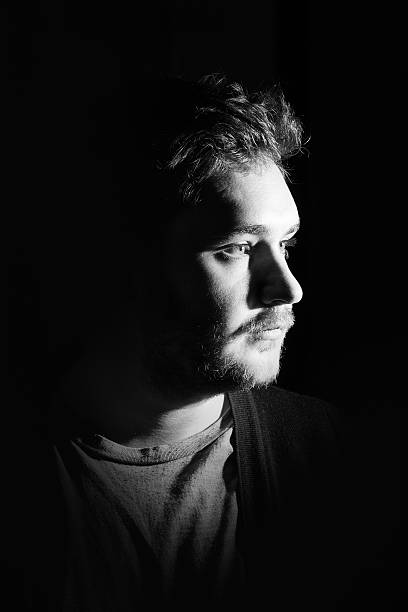istock Young man's portrait. Close-up face against black background 515600522