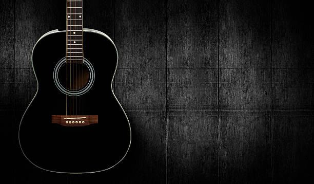 istock Black acoustic guitar on dark black wooden background. 515601968