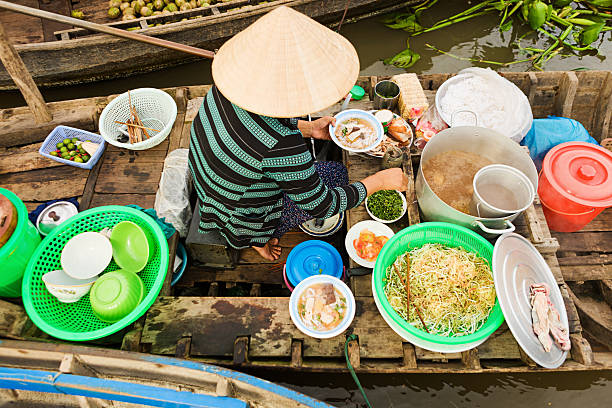 mujer pho vietnamita venta-sopa de fideos en el mercado flotante - noodle soup fotografías e imágenes de stock