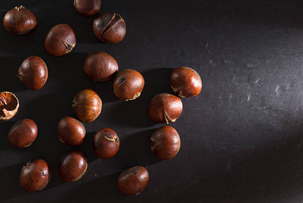 Group of chestnuts. Dark background. stock photo