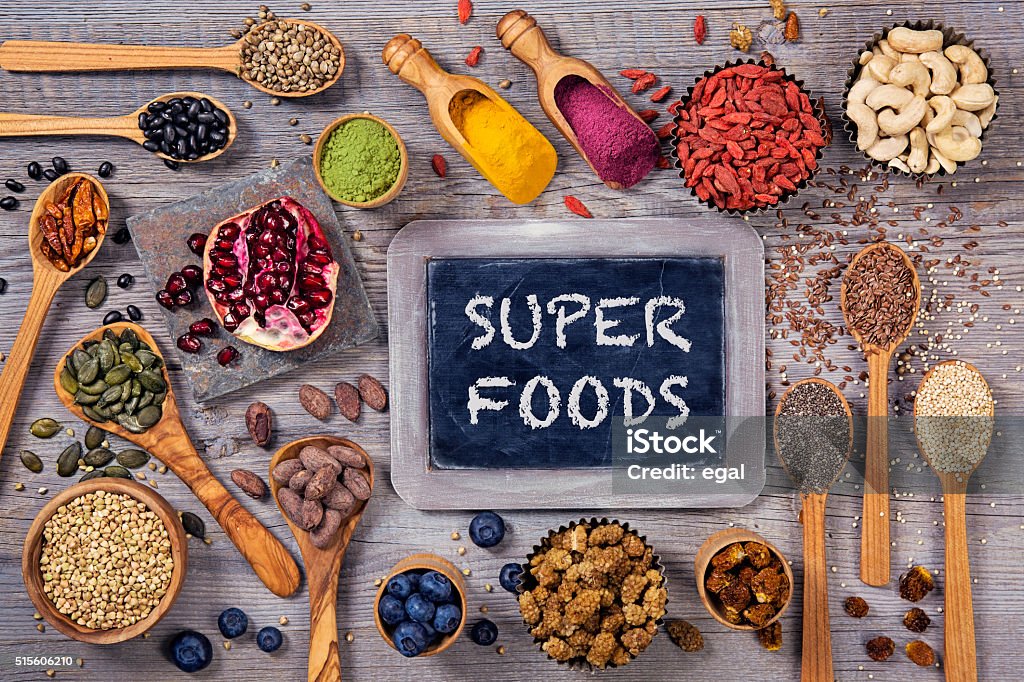 Super foods in spoons and bowls Super foods in spoons and bowls on a wooden background Antioxidant Stock Photo
