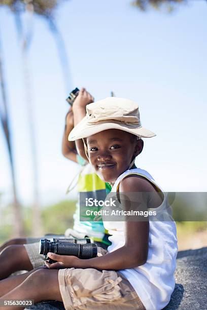 African Boy And Girl Sitting On A Rock Stock Photo - Download Image Now - Africa, African Ethnicity, Binoculars