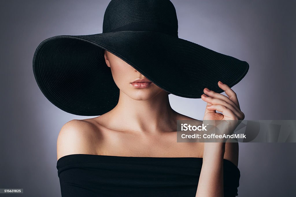 Studio shot of young beautiful woman Studio shot of young beautiful woman on dark background in retro style Hat Stock Photo