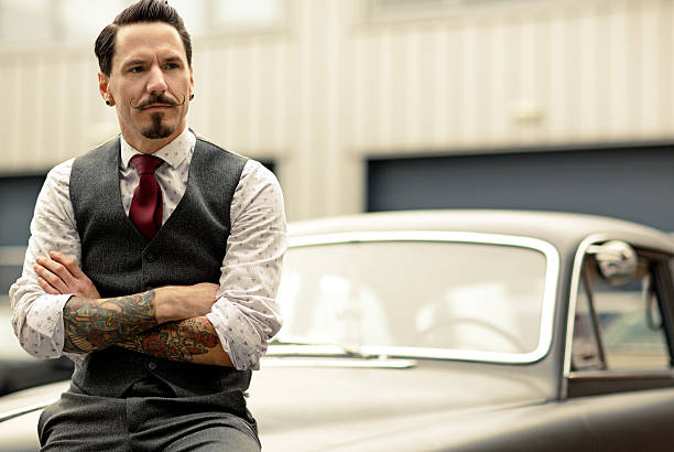Man with moustaches sitting on retro  car