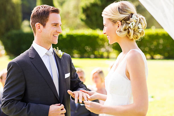istock Bride Putting Wedding Ring On Groom's Finger 515631987