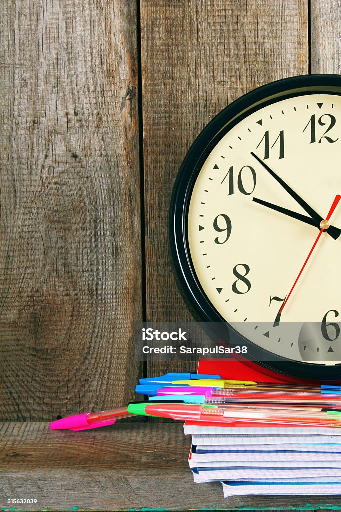 Watches and school tools. On wooden background. Watches and school tools. On a wooden background. Clock Stock Photo