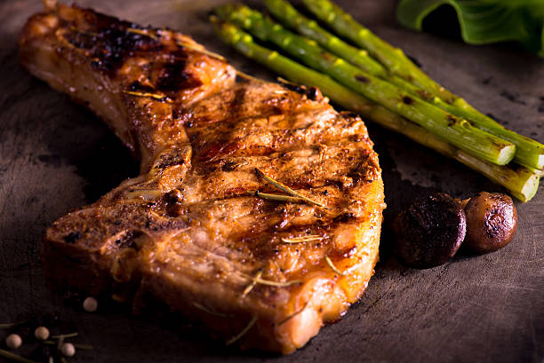 grilled pork chop with vegetable on wooden board stock photo