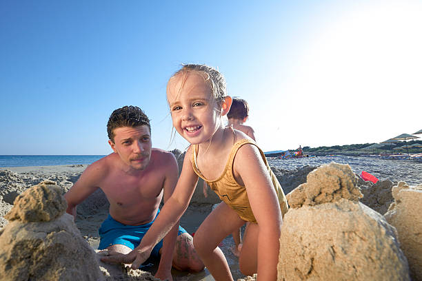 istock Family playing in sand on beach 515646026