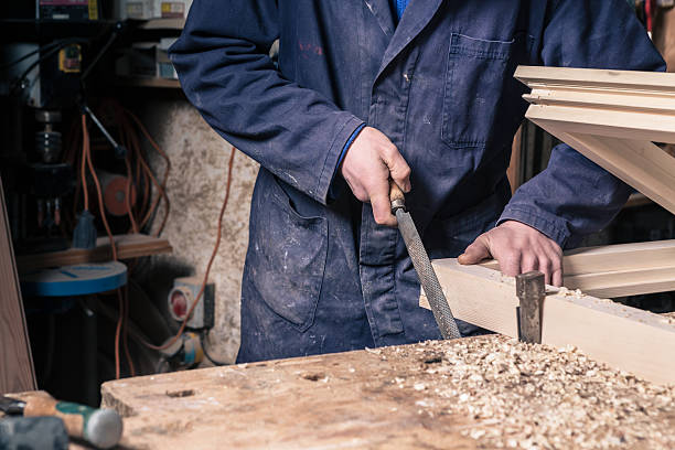 istock Carpenter working on a Wooden Window Frame with a File 515646626