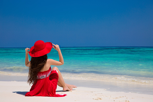 Happy woman enjoying beach relaxing joyful on white sand in summer by tropical blue water. Bliss freedom beach concept. Good life. Vacation.