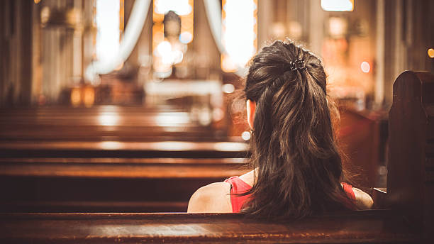 Woman visiting a christian church Woman visiting a christian church pew stock pictures, royalty-free photos & images