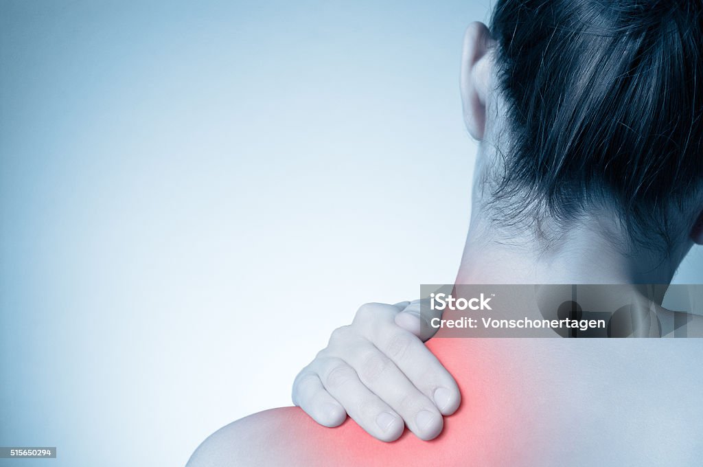 Woman with back pain Rear view of a young woman touching her back Adult Stock Photo