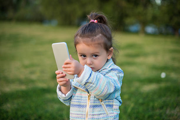 istock Cute toddler girl using smart phone 515651780