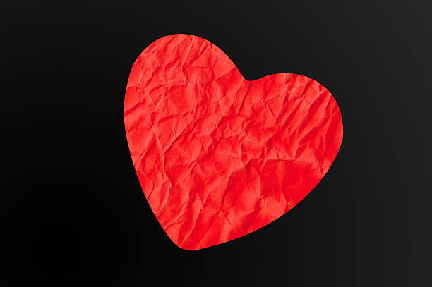 istock Crumpled paper heart on black background 515652196