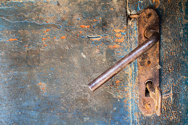 istock Old wooden cracked door with iron rusty lock and key 515653018