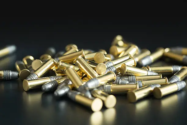 Photo of .22 caliber bullets stacked on a black background.