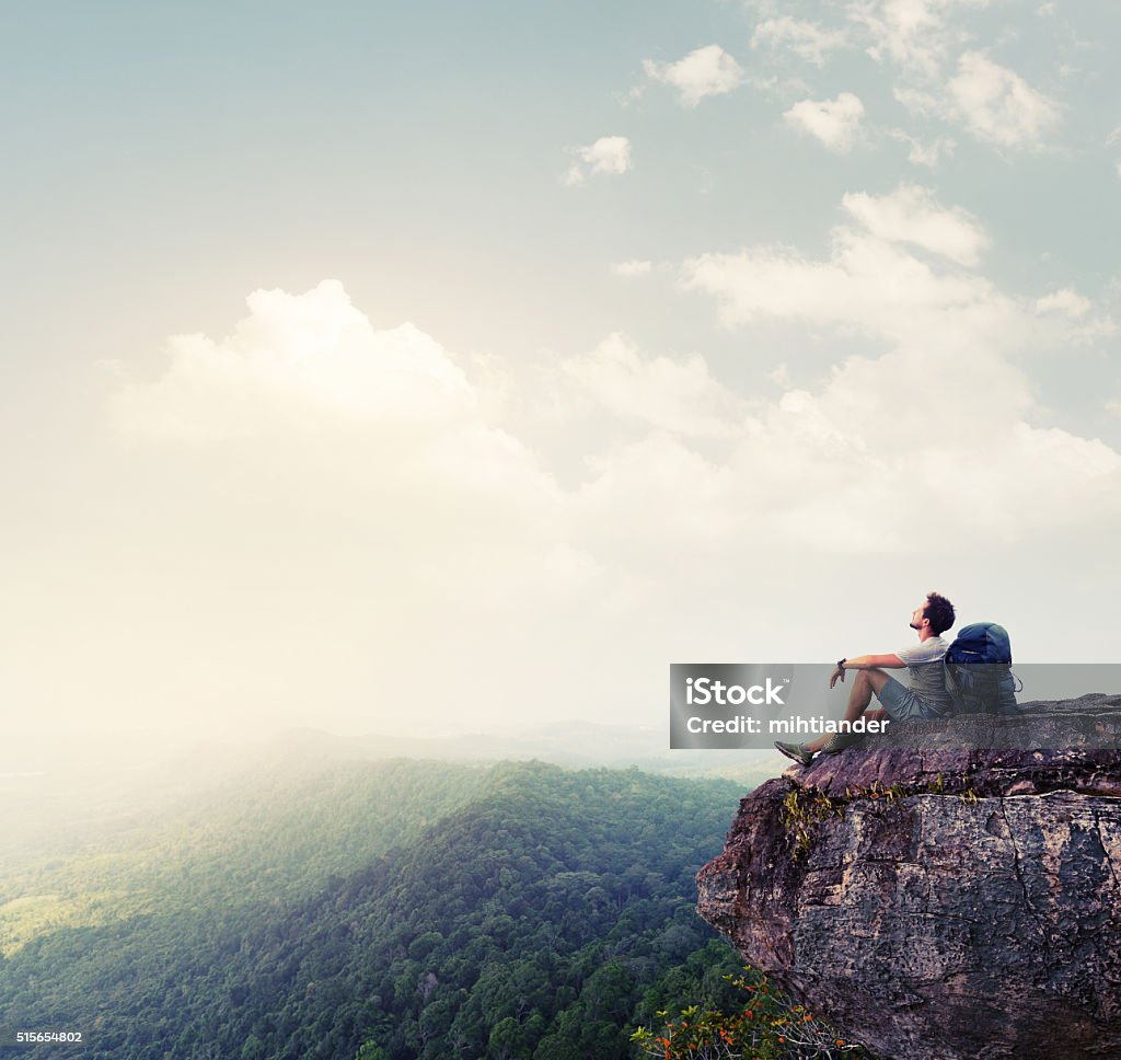 Hiker relaxing on the rock Hiker relaxing on the rock with a backpack Adventure Stock Photo