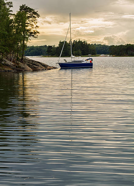 Sailboat anchored at island in Stockholm archipelago at night.