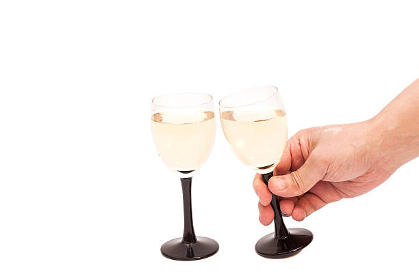 istock Hand holds glass goblet with champagne isolated on white background 515656438