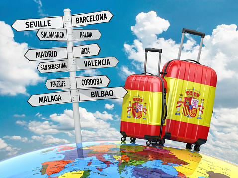 Travel concept. Suitcases and signpost what to visit in Spain