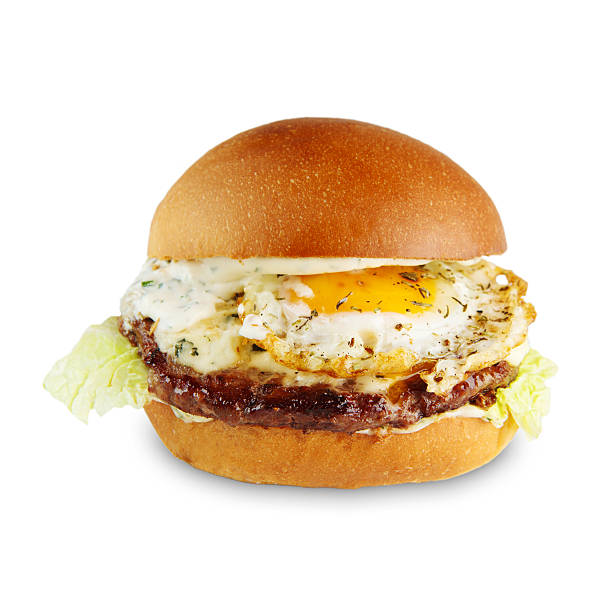 Classic american burger food, cheeseburger with beef or pork meat, fresh bun, fried egg, white mayonnaise sauce, closeup isolated at white background - fast food delivery, takeaway menu