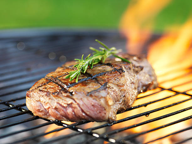 istock steak with flames on grill with rosemary 515658371