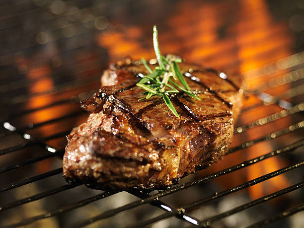 istock steak cooking over flaming grill 515658379