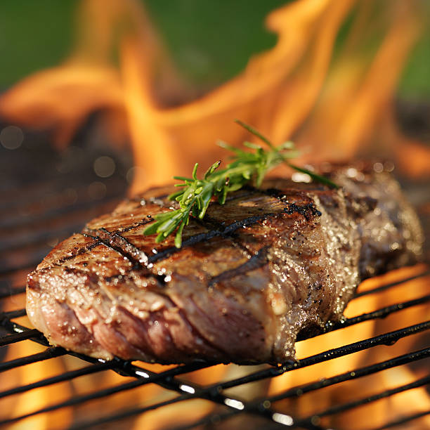 istock steak cooking over flaming grill 515658383