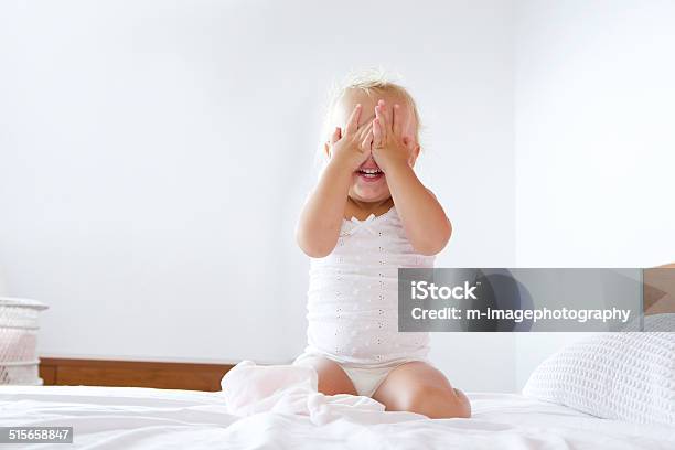 Linda Niña Esconde Manos Tapando Cara Foto de stock y más banco de imágenes de Bebé - Bebé, Niño pequeño, Cama