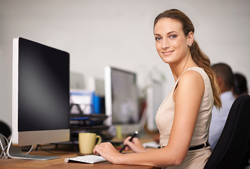 Portrait of an attractive young office worker at her computer