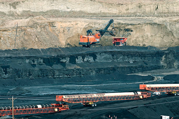 istock Crane loading truck with dirt covering layer of coal 515664079